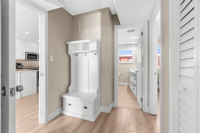 mudroom with visible vents, light wood-style flooring, and baseboards