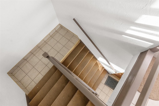 stairs featuring a textured ceiling and tile patterned floors