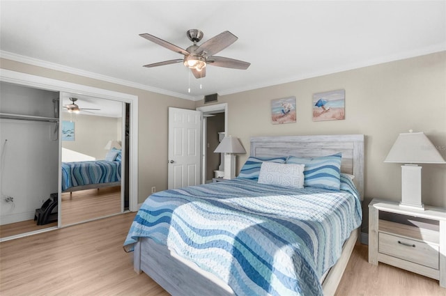 bedroom with light wood-style floors, a closet, ornamental molding, and ceiling fan