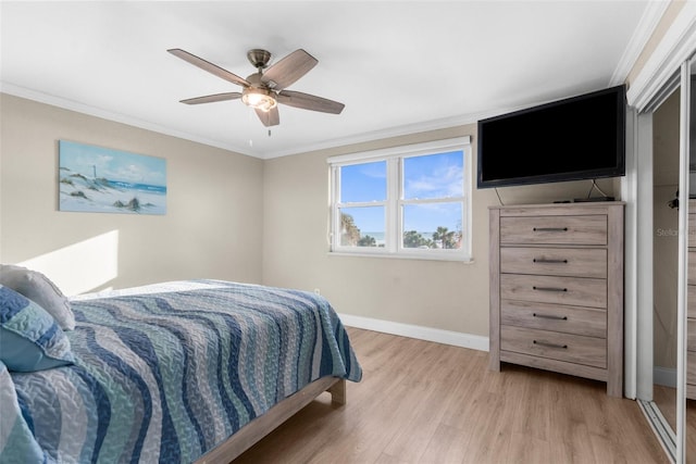 bedroom with light wood finished floors, baseboards, ornamental molding, and a ceiling fan