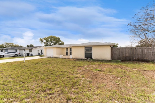 view of front facade with brick siding, concrete driveway, a front yard, fence, and a garage