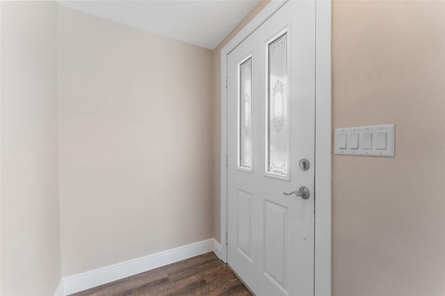 doorway to outside featuring dark wood-type flooring and baseboards