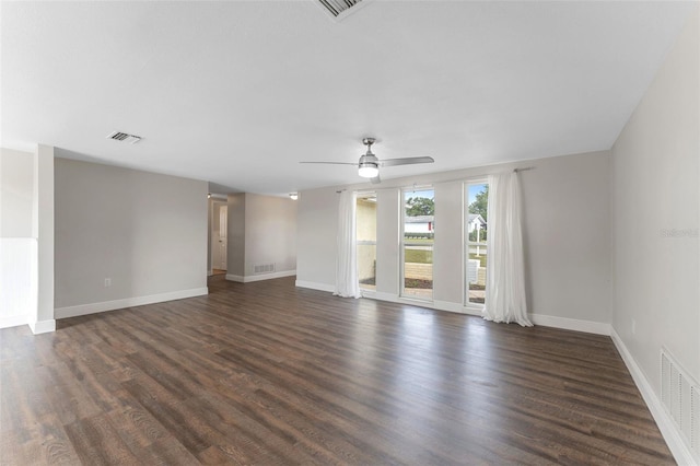 spare room featuring dark wood-style floors, ceiling fan, and visible vents