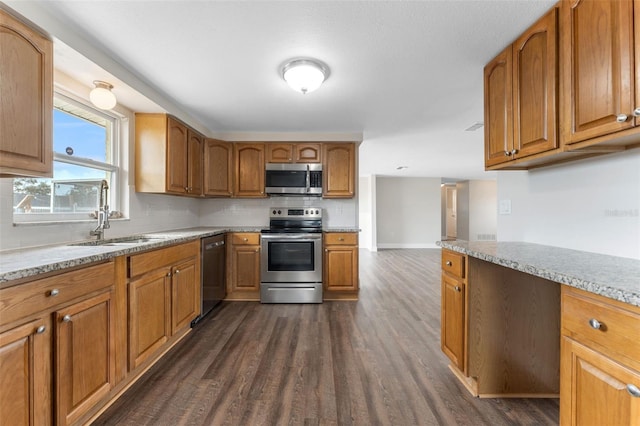 kitchen featuring brown cabinets, stainless steel appliances, backsplash, dark wood-type flooring, and a sink