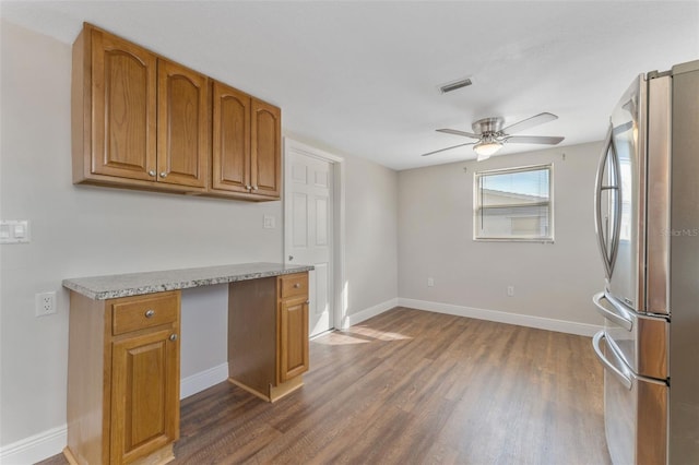 kitchen with ceiling fan, baseboards, built in study area, freestanding refrigerator, and dark wood-style floors