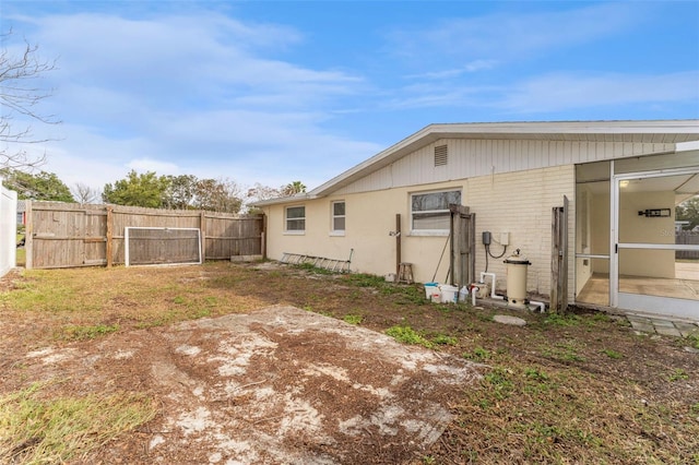 back of house featuring brick siding and a fenced backyard