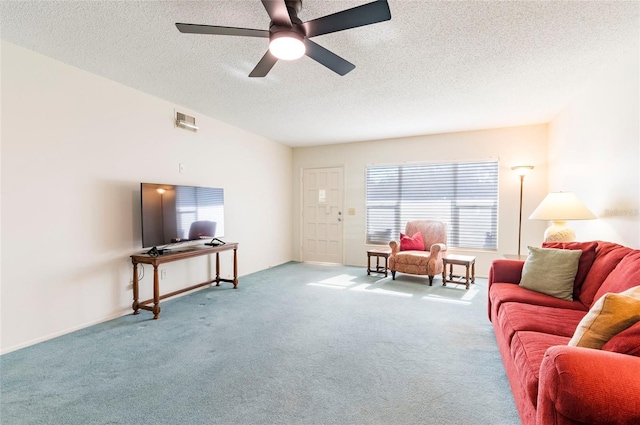 living area with light carpet, a textured ceiling, visible vents, and a healthy amount of sunlight