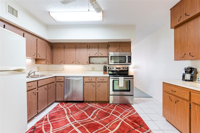 kitchen featuring visible vents, stainless steel appliances, a sink, and light countertops