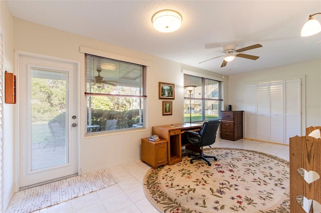 office space with light tile patterned floors, plenty of natural light, a textured ceiling, and ceiling fan