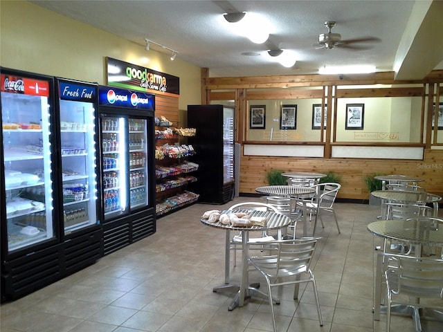 interior space with a textured ceiling, wood walls, and tile patterned flooring