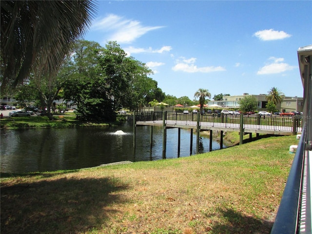 dock area with a water view and a lawn