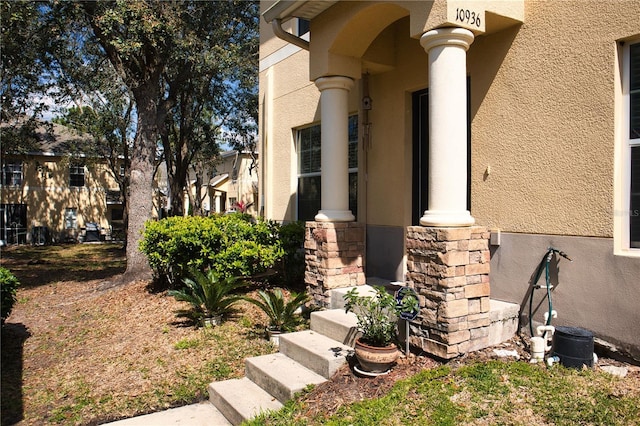 entrance to property with stone siding and stucco siding