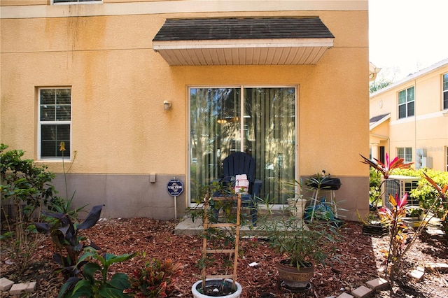 entrance to property featuring central AC unit and stucco siding