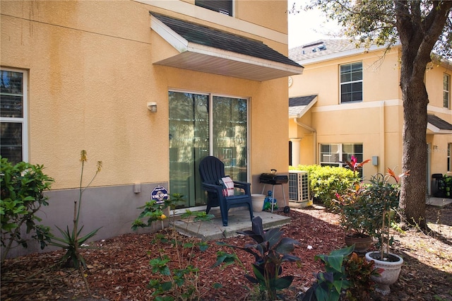 back of property featuring cooling unit, a patio, and stucco siding