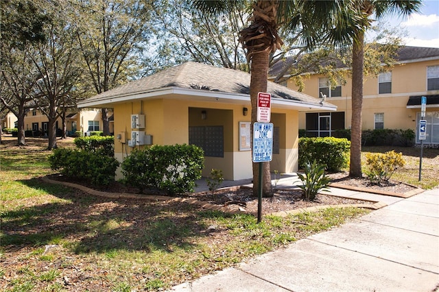 view of front of property with a shingled roof and stucco siding