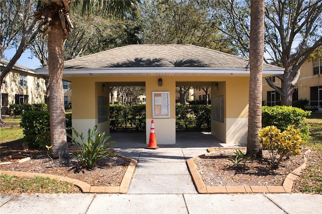 view of front of home featuring roof with shingles and stucco siding