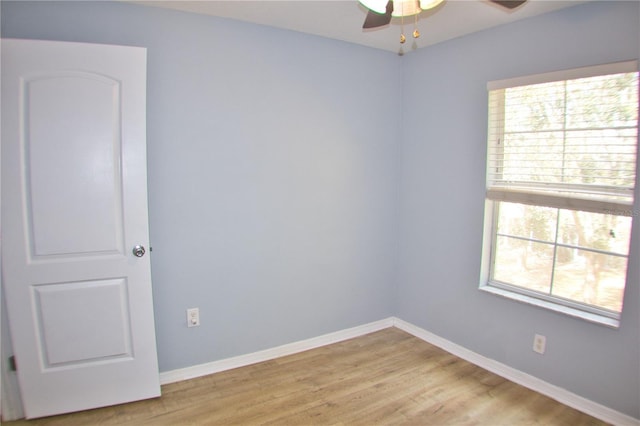 empty room with ceiling fan, light wood-style flooring, and baseboards