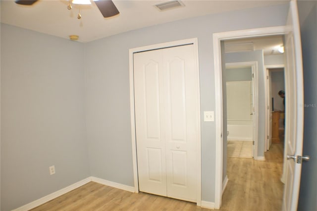 unfurnished bedroom with light wood-style floors, a closet, visible vents, and baseboards