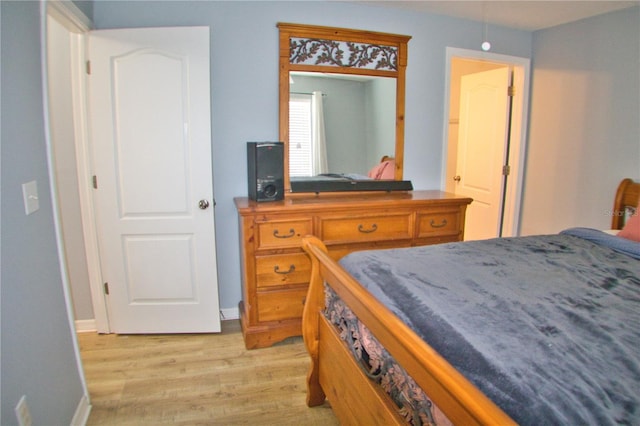 bedroom with light wood-style flooring and baseboards