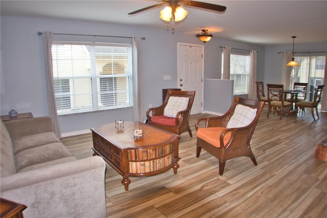 living room with light wood-style floors, plenty of natural light, and baseboards