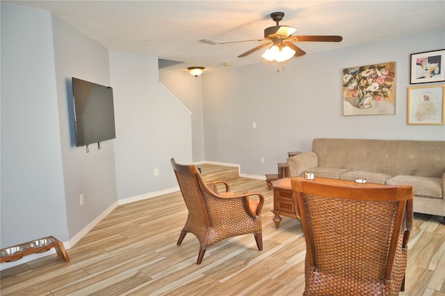 living area with ceiling fan, light wood-type flooring, and baseboards