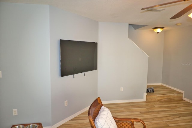 interior space with ceiling fan, baseboards, and wood finished floors