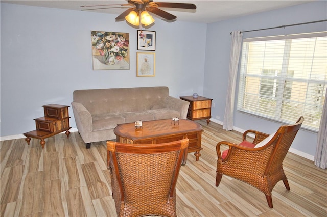 living room with ceiling fan, light wood-type flooring, and baseboards