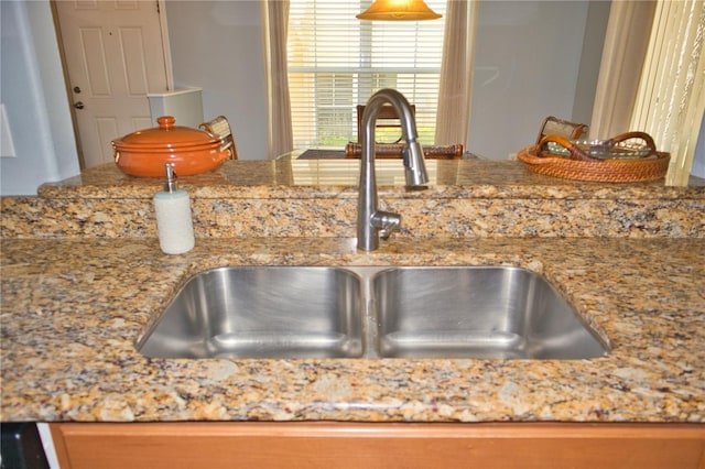 room details featuring light stone counters and a sink