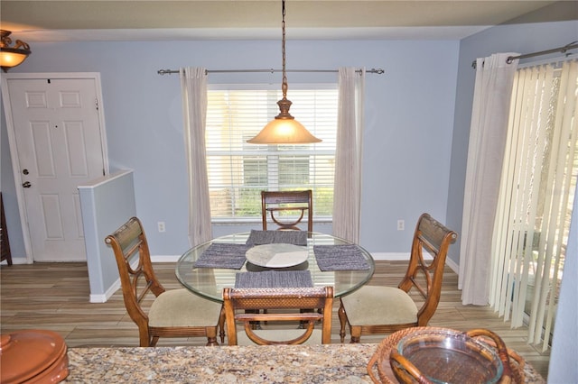 dining space featuring light wood finished floors and baseboards