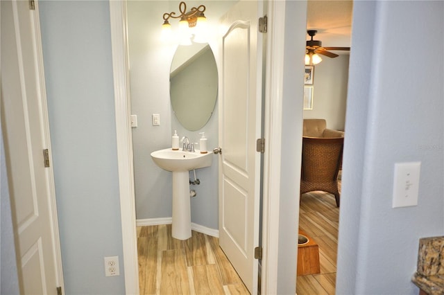 bathroom featuring a ceiling fan, baseboards, and wood finished floors