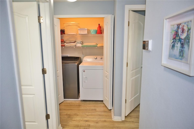 laundry room with laundry area, light wood-style floors, and washer and dryer