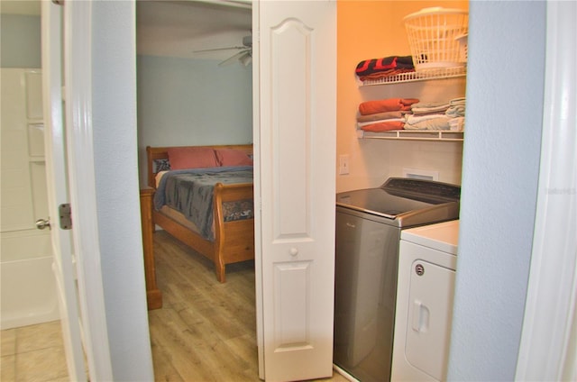 washroom featuring laundry area, ceiling fan, washer and clothes dryer, and light wood-style flooring