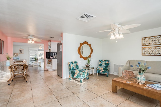 living room featuring light tile patterned floors, visible vents, and a ceiling fan