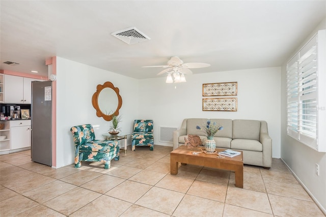 living area with light tile patterned floors, ceiling fan, and visible vents