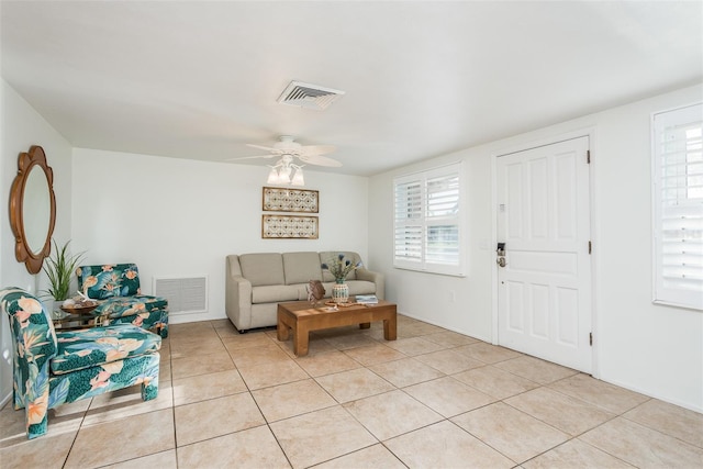 living room featuring light tile patterned floors, visible vents, and a healthy amount of sunlight