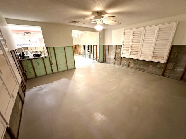 spare room with concrete floors and a ceiling fan