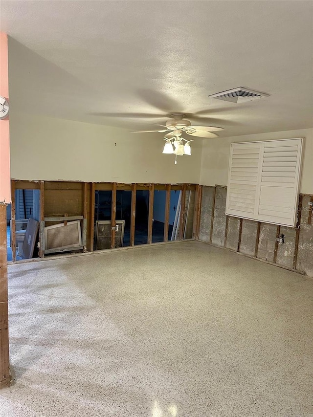 empty room with ceiling fan, speckled floor, a textured ceiling, and visible vents