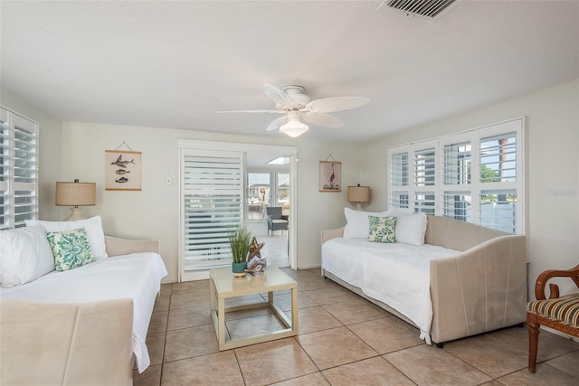 bedroom featuring light tile patterned flooring, visible vents, and a ceiling fan