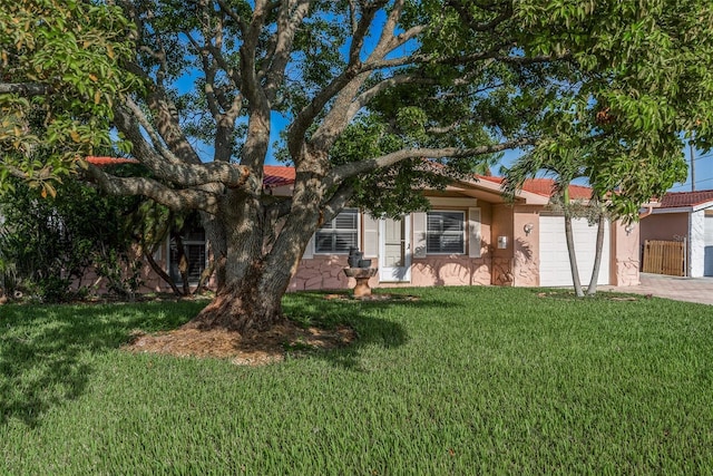 view of front of property with an attached garage, a front lawn, and decorative driveway