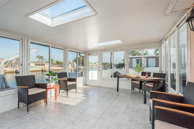 sunroom featuring a water view