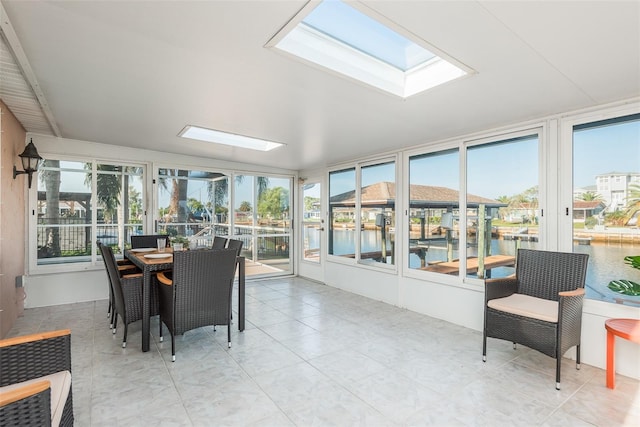 sunroom featuring a skylight and a water view