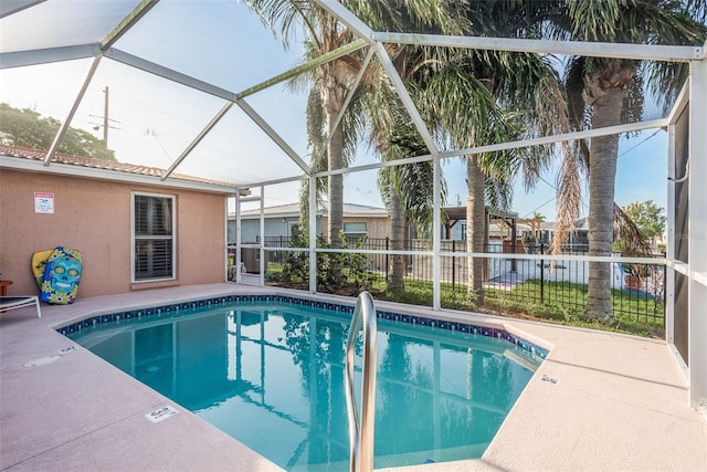 view of pool featuring glass enclosure, a patio area, fence, and a fenced in pool