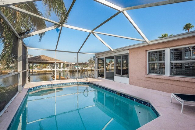 pool with a lanai, a water view, and a patio