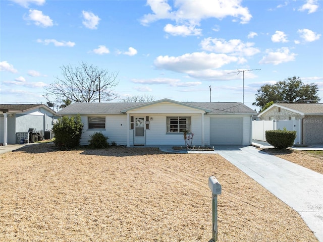 ranch-style house featuring a garage, fence, and concrete driveway