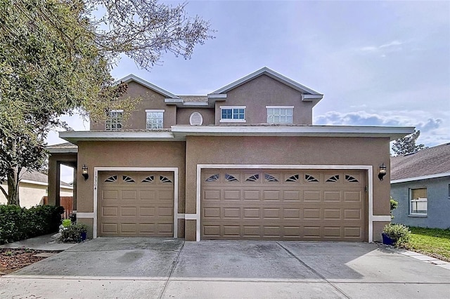 view of front of property with concrete driveway, an attached garage, and stucco siding