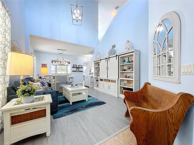 interior space with wood finished floors, a towering ceiling, and an inviting chandelier