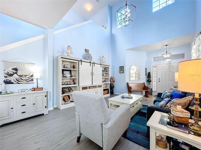 living room with an inviting chandelier, plenty of natural light, and wood finished floors