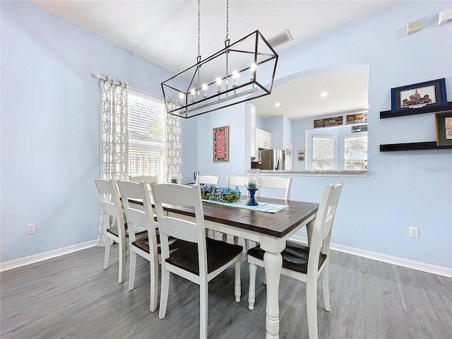 dining room featuring a wealth of natural light, wood finished floors, visible vents, and baseboards