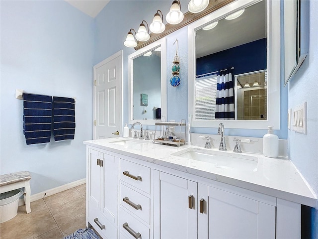 bathroom with tile patterned flooring, tiled shower, a sink, and double vanity