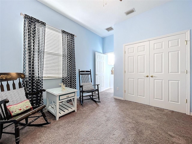 living area with baseboards, visible vents, and carpet flooring